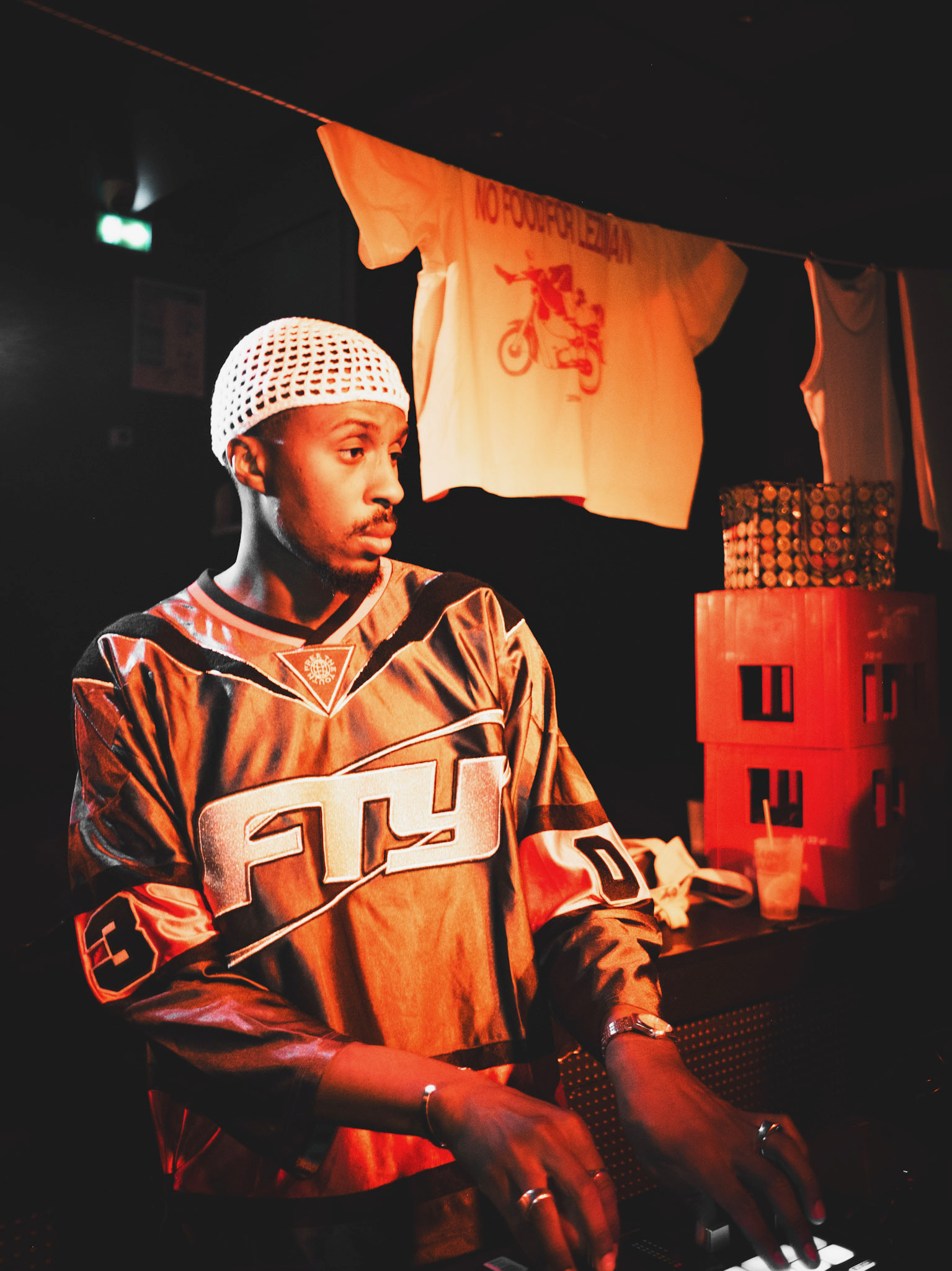 DJ Wayans en set, bonnet blanc et maillot, lumière rouge
