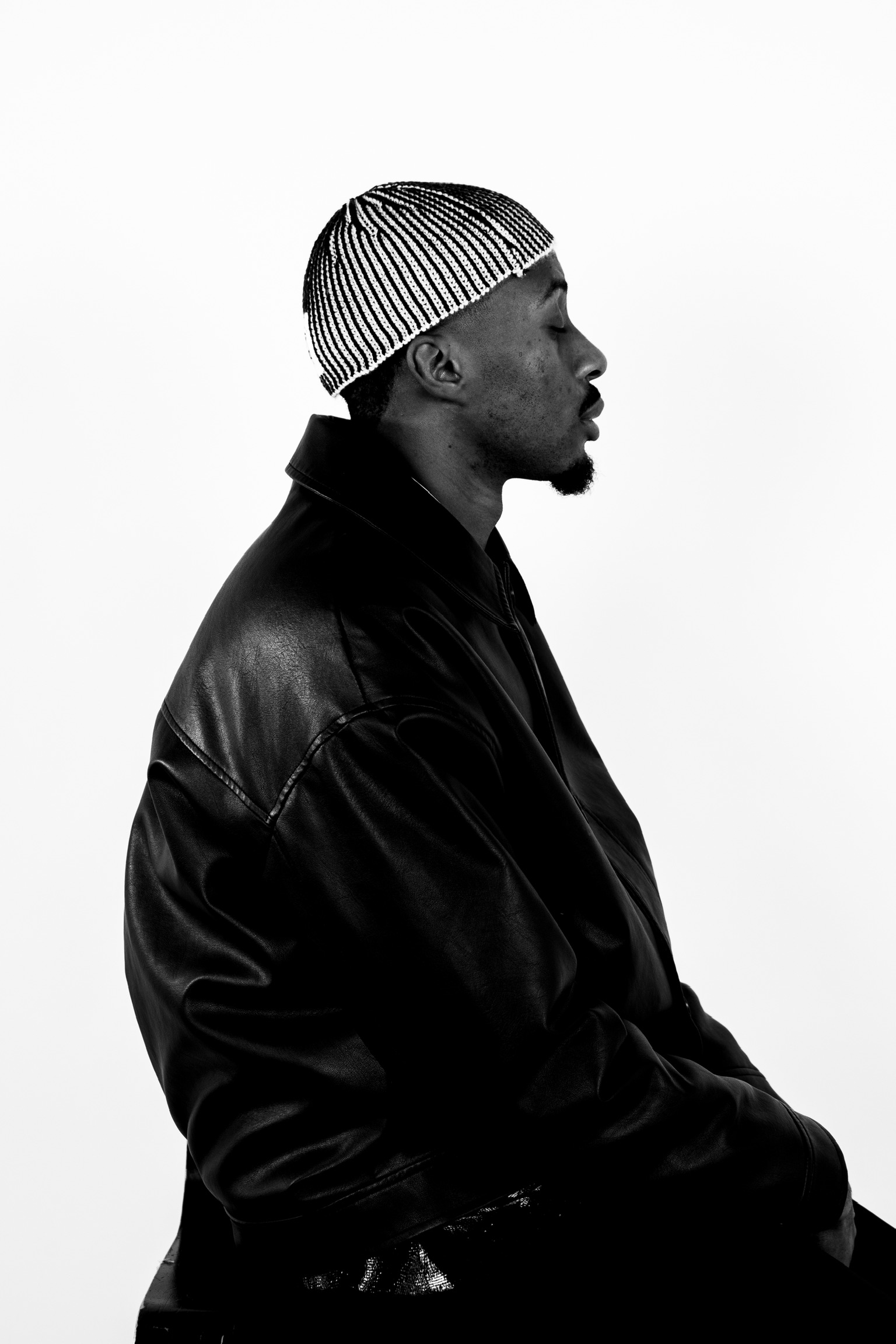 Portrait noir et blanc de DJ Wayans, de profil, yeux fermés