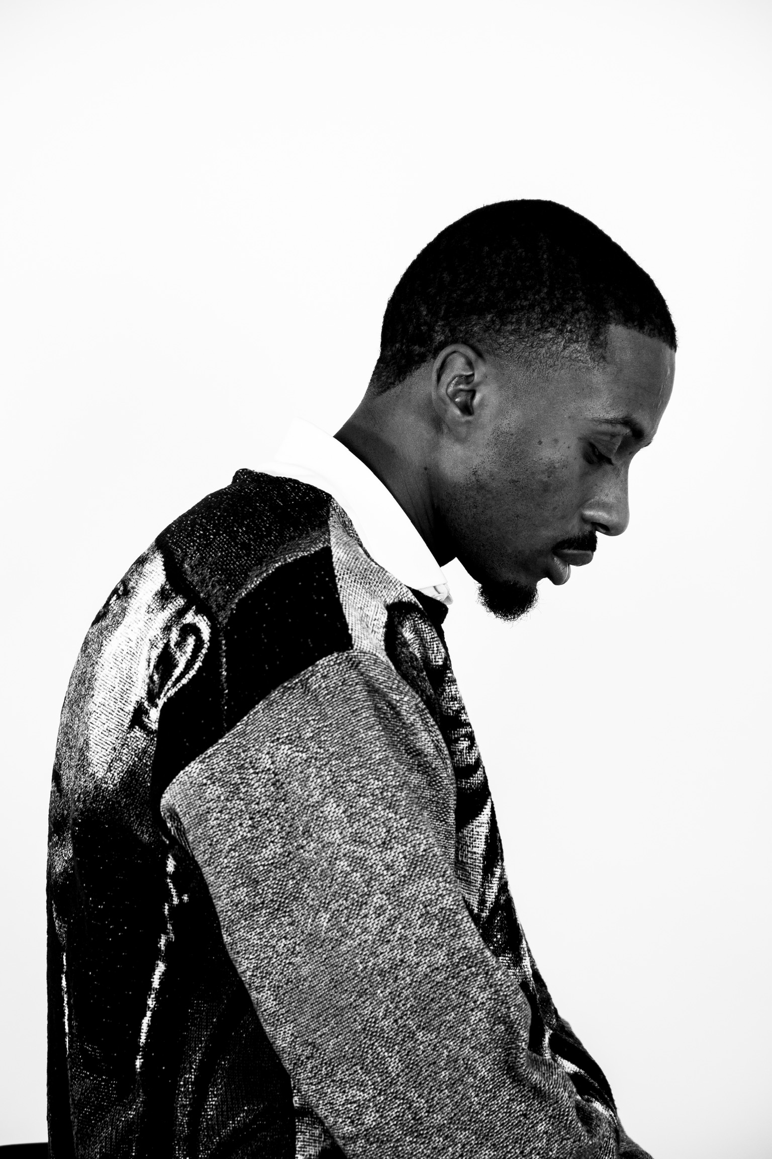 Portrait noir et blanc de DJ Wayans, de profil, tête baissée